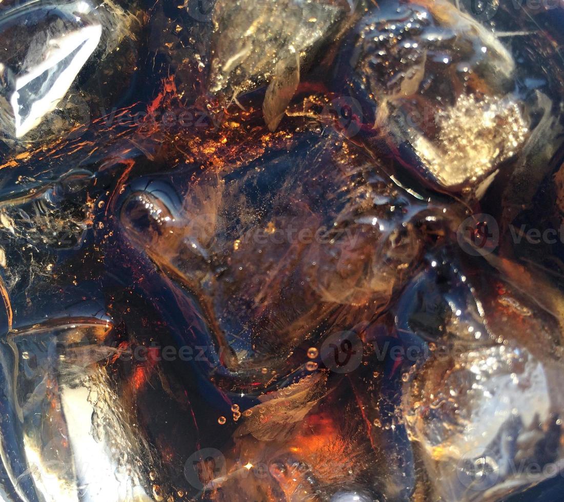 detailopname van ijs kubussen in een glas met cola foto