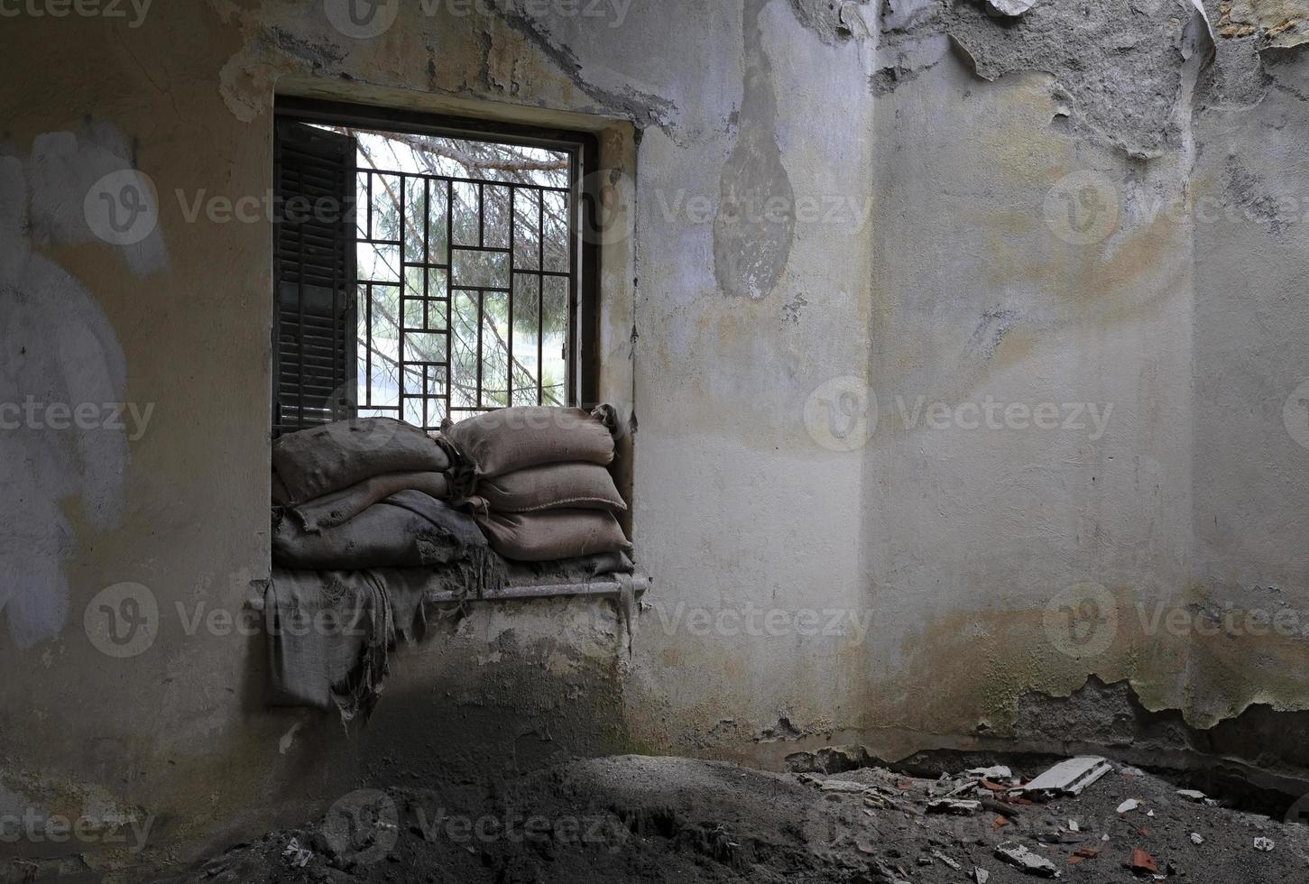 zandzakken opgestapeld omhoog Bij een venster van een huis in de buffer zone groen lijn in Nicosia, Cyprus foto