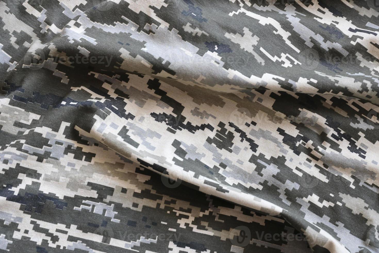 kleding stof met structuur van oekraïens leger korrelig camouflage. kleding met camo patroon in grijs, bruin en groen pixel vormen. officieel uniform van oekraïens soldaten foto