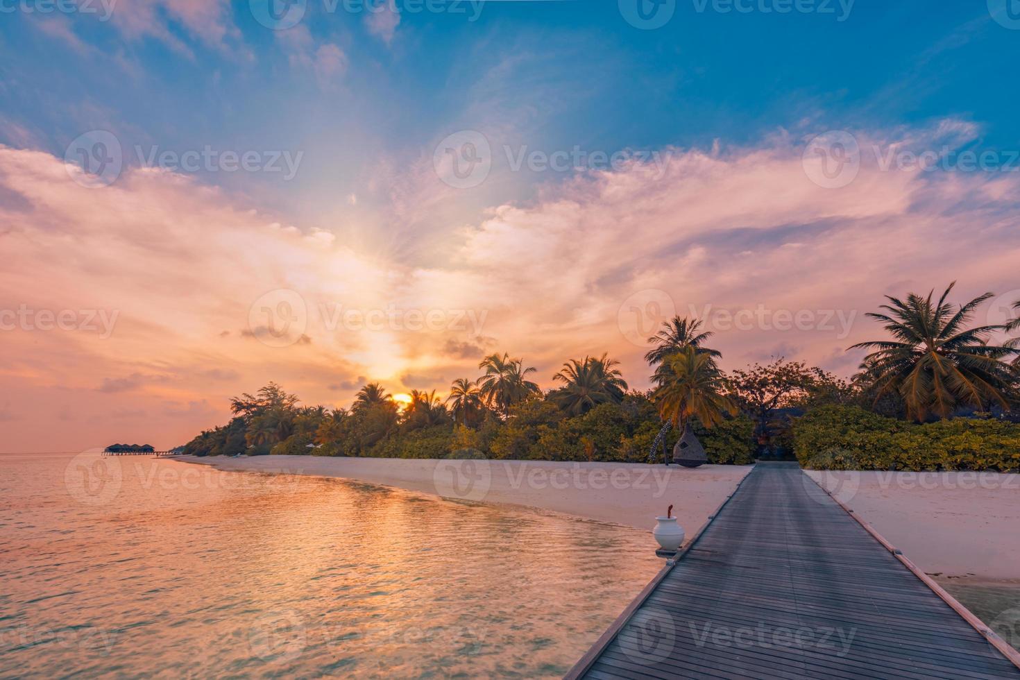 zonsondergang Aan Maldiven eiland, luxe toevlucht houten pier pad. fantastisch kleurrijk lucht wolken reflectie strand zee horizon. zomer romantisch vakantie vakantie, reizen concept. paradijs zonsondergang landschap foto