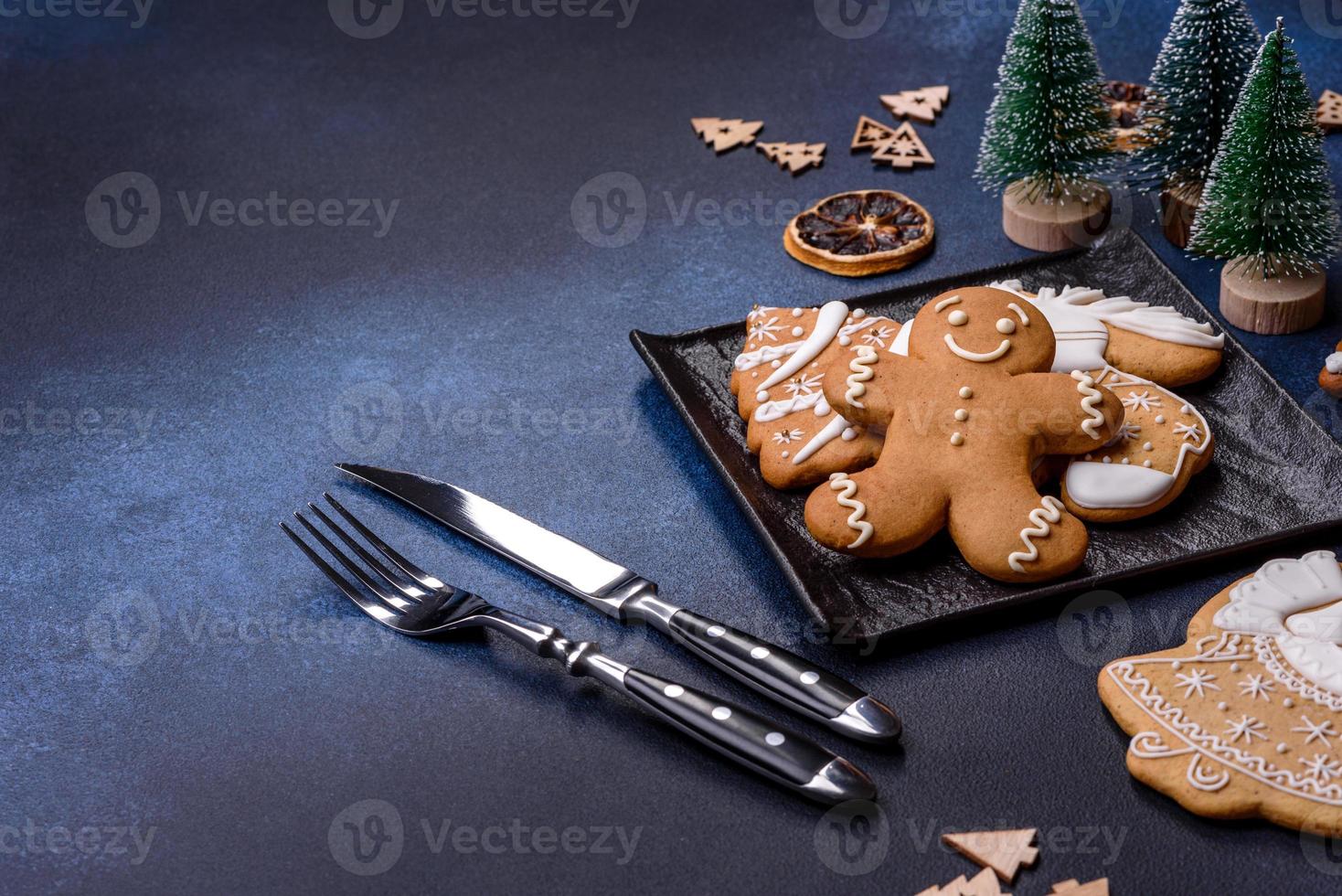 Kerstmis decoraties en peperkoeken Aan een donker beton tafel. krijgen klaar naar viering foto