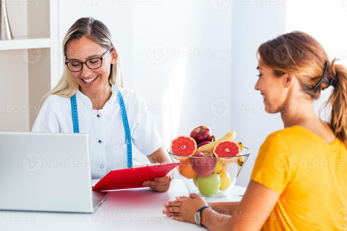 dokter voedingsdeskundige, diëtist en vrouw geduldig Aan overleg in de kantoor. vrouw voedingsdeskundige geven overleg naar geduldig. maken eetpatroon plan. foto