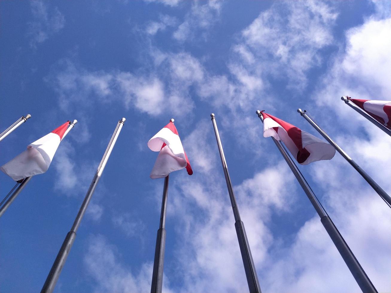 Indonesisch vlag Aan een blauw lucht achtergrond foto