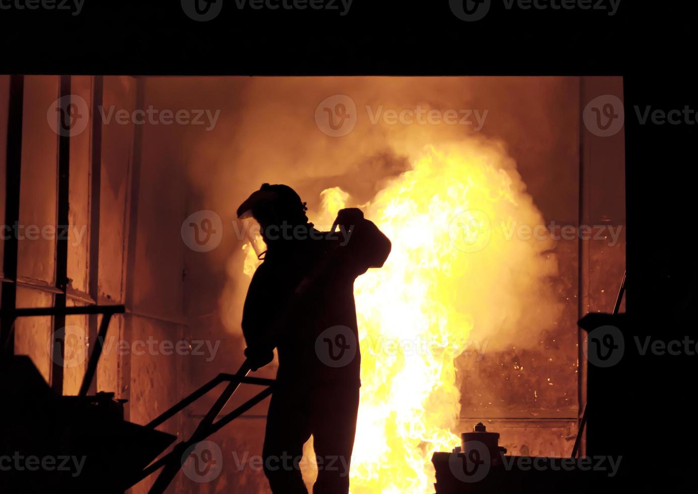 man aan het werk in het spatten gesmolten ijzer - stock beeld foto