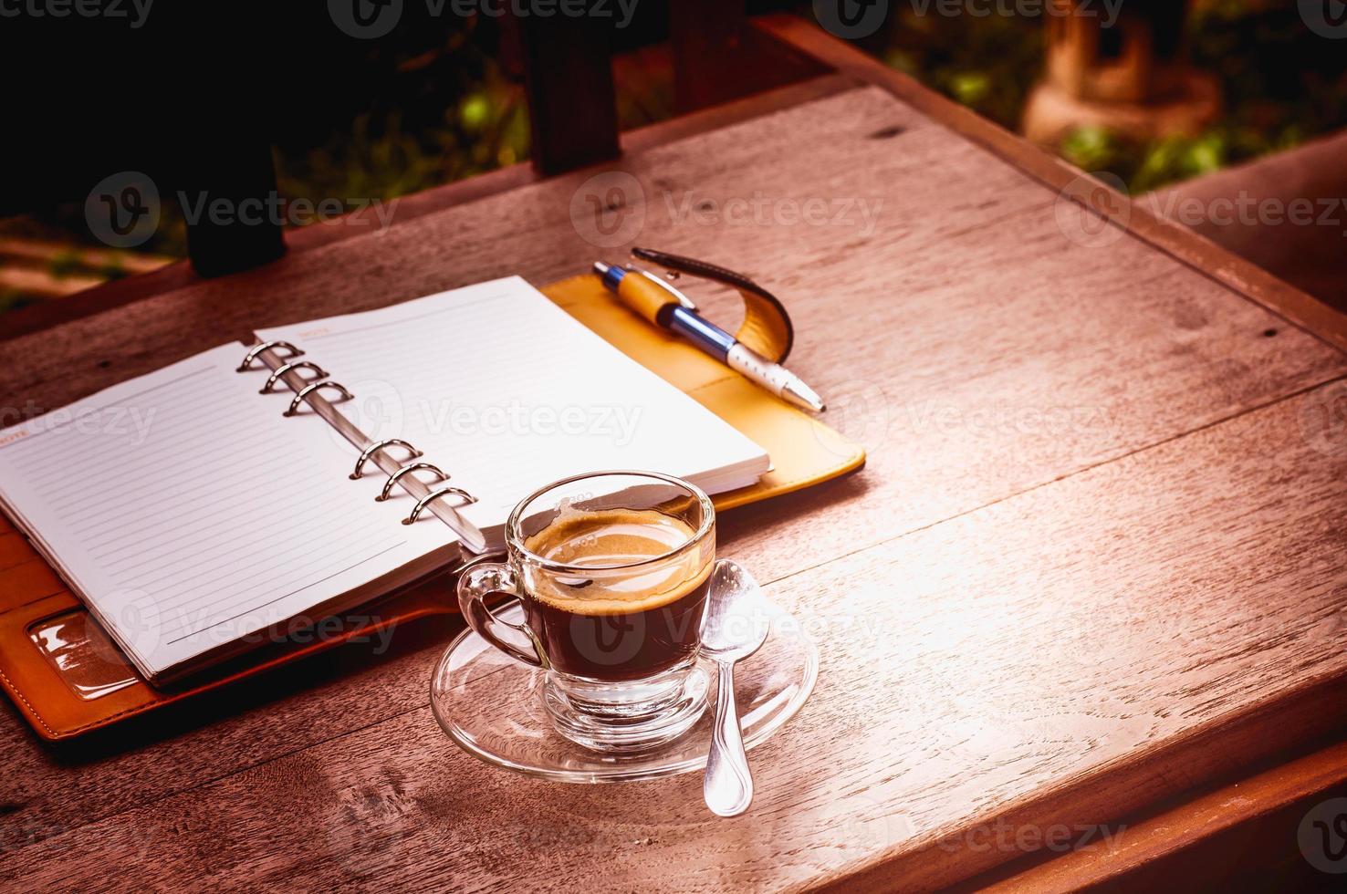 notitieboekje en koffiekop op oude houten achtergrond, bedrijfsconce foto