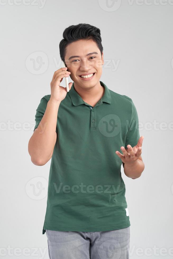 portret van een opgewonden jong Aziatisch Mens pratend Aan mobiel telefoon geïsoleerd over- wit achtergrond foto