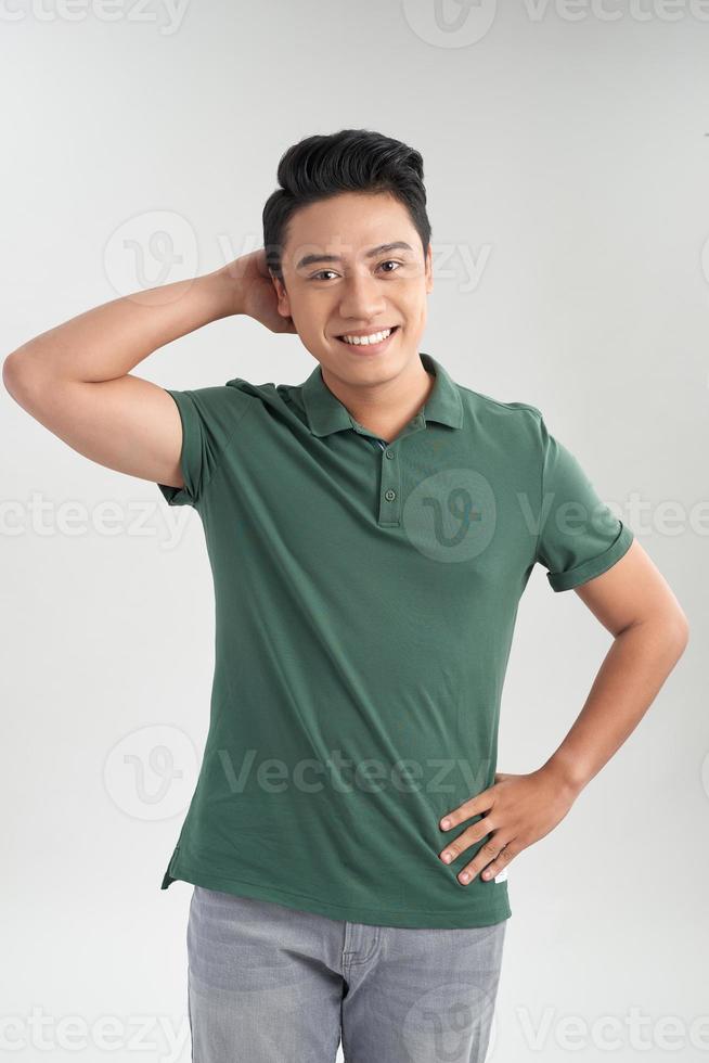 aantrekkelijk gewoontjes Mens staand terwijl vervelend blauw jeans en groen t-shirt Aan wit achtergrond foto