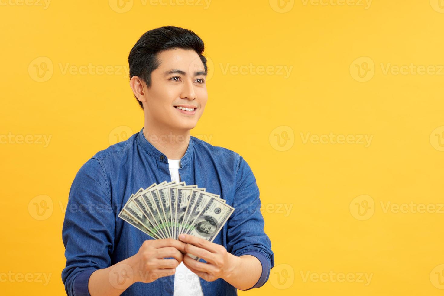 geschokt jong Mens Holding ventilator van contant geld geld in dollar bankbiljetten foto