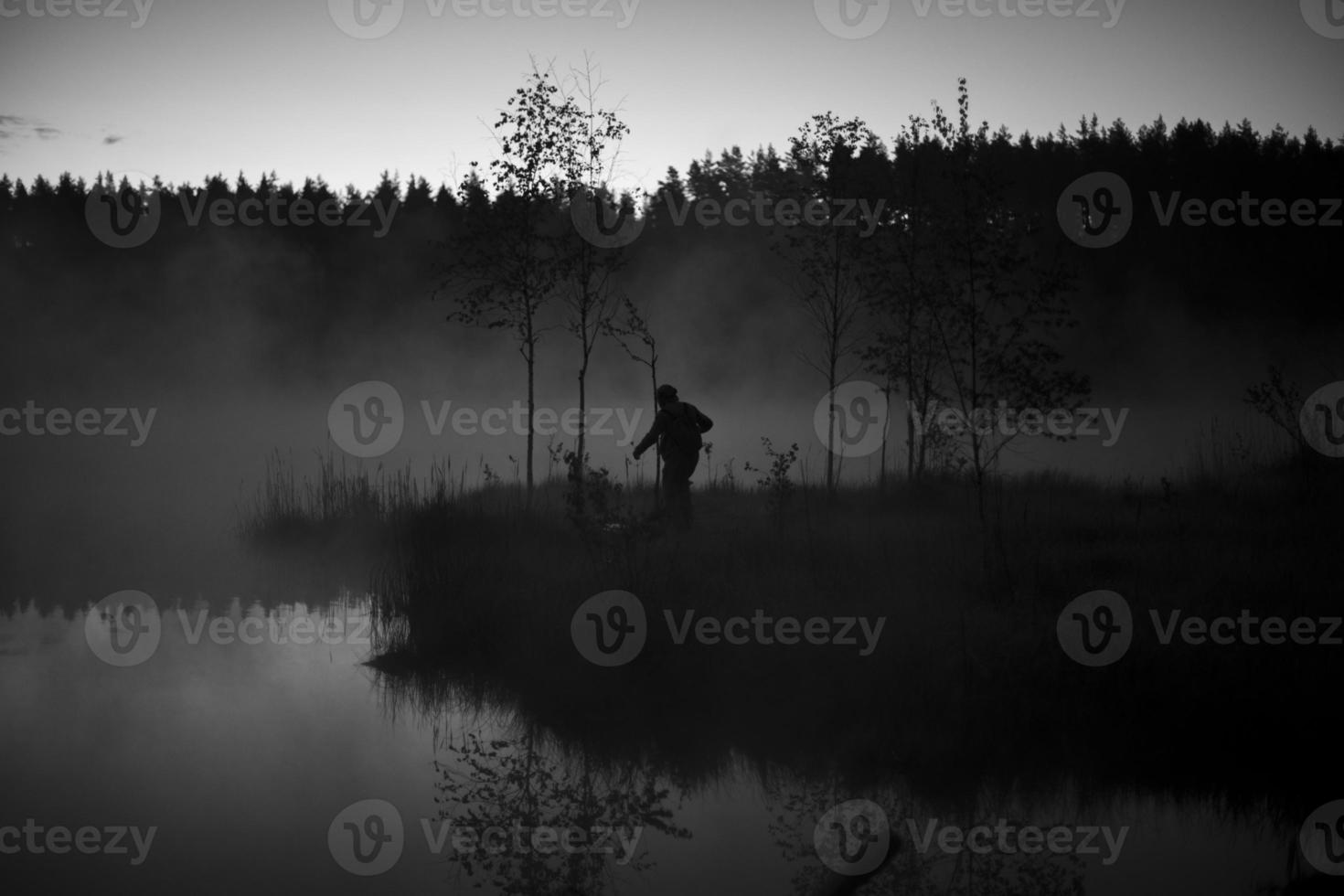 Mens in mist Aan meer. Mens wandelingen naar water. mystiek mist in Woud. buitenshuis recreatie. foto