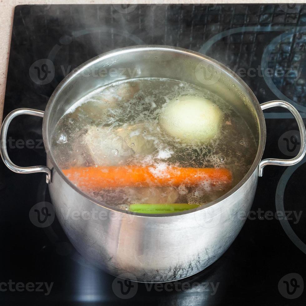 koken vlees bouillon in soeppan Aan keramisch kookplaat foto