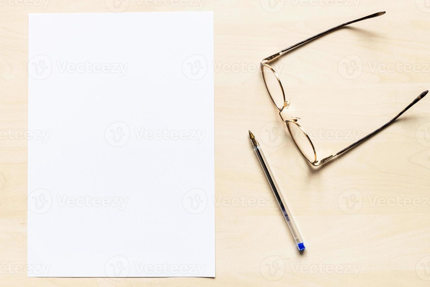 bril, pen en blanco vel van wit papier foto