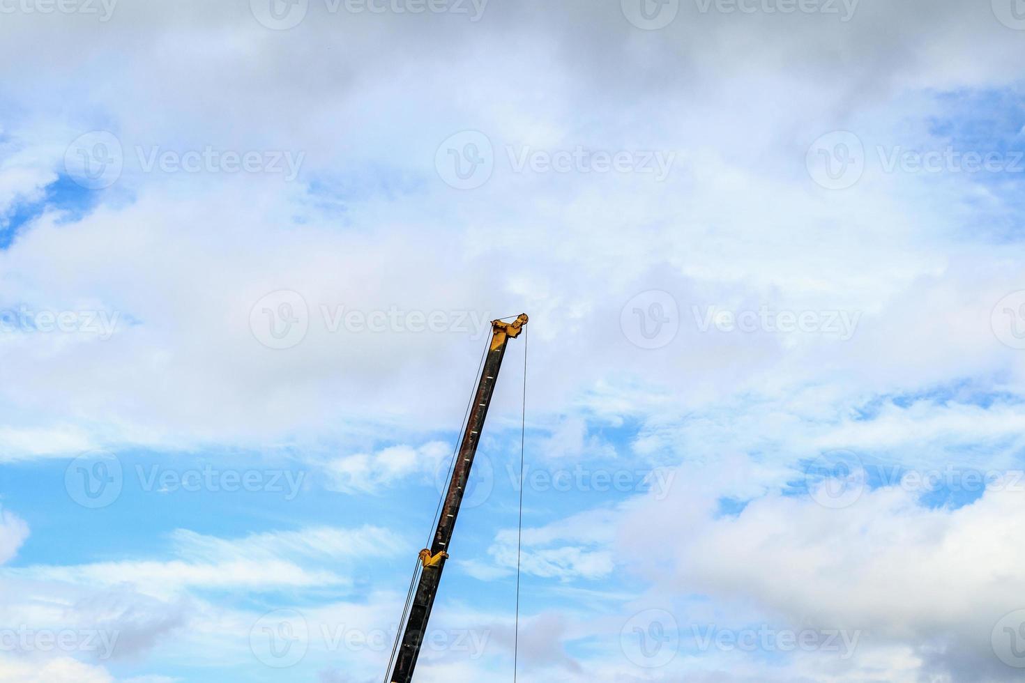 telescopische armen van mobiele bouwkraanwagen met wolken en blauwe lucht foto