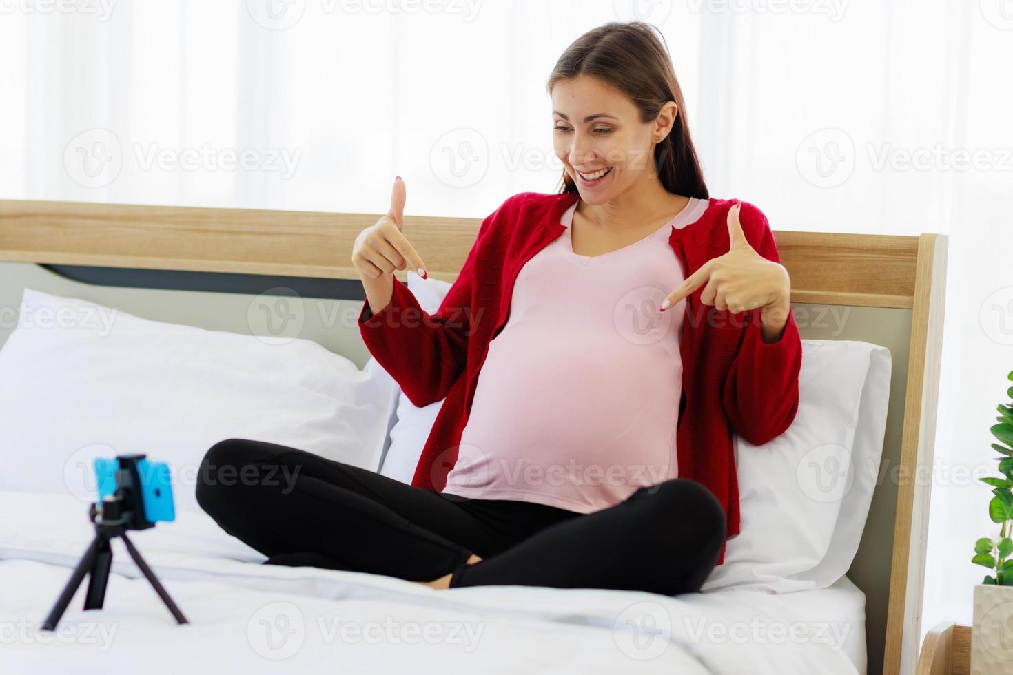 mooi Kaukasisch vrouw gelukkig zwanger Aan een video telefoontje Aan haar smartphone. nieuw moeders communiceren draadloos met modern communicatie apparaten. foto