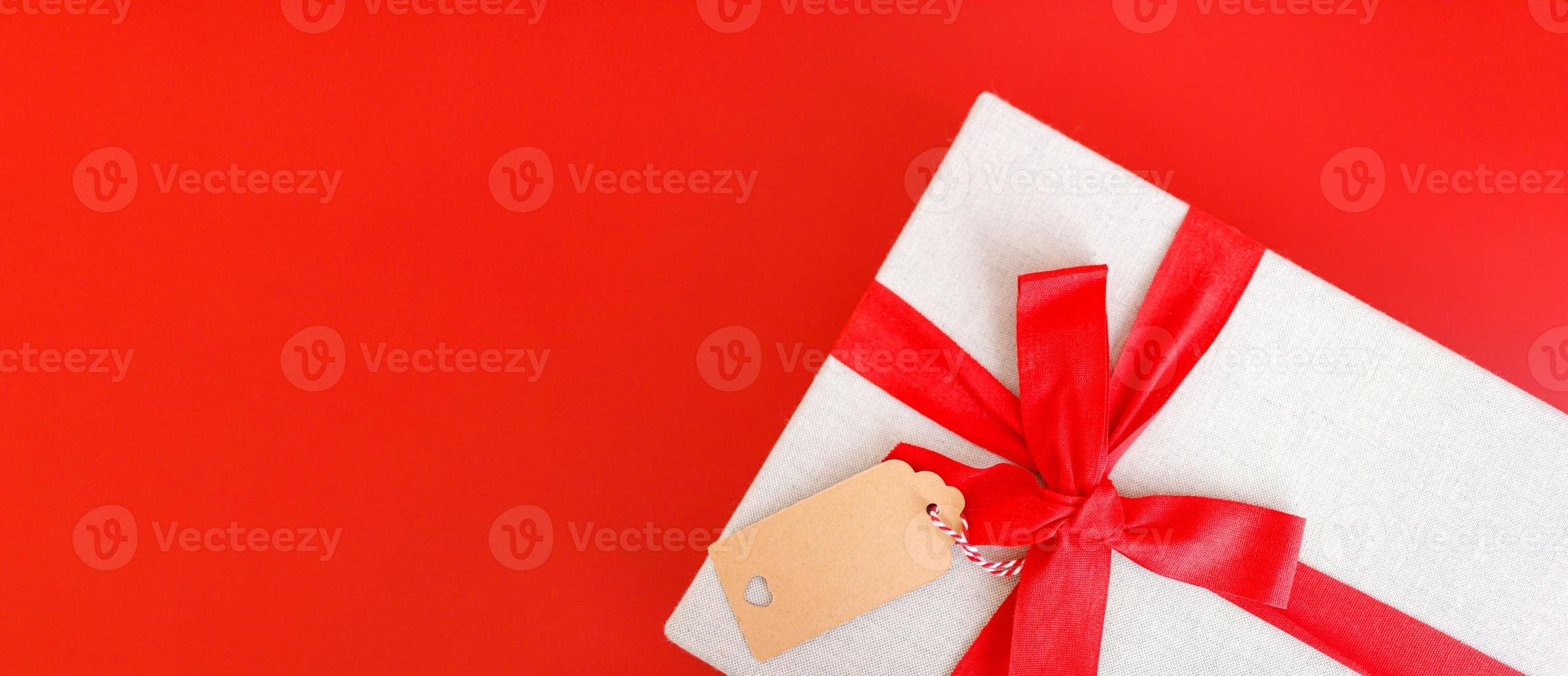 rood banier met geschenk doos gebonden rood linten foto