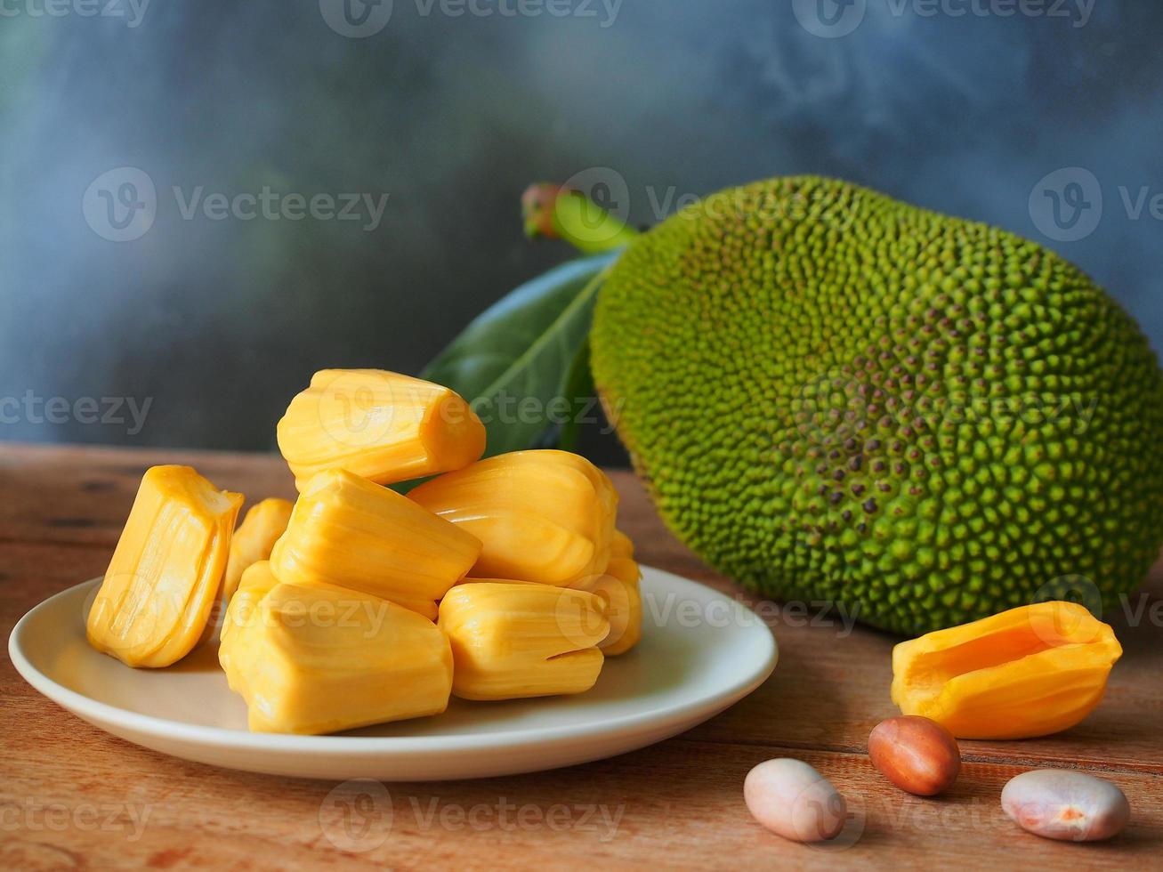 rijp jackfruit vlees in wit bord Aan houten tafel voor tropisch fruit of vlees plaatsvervanger concept. foto