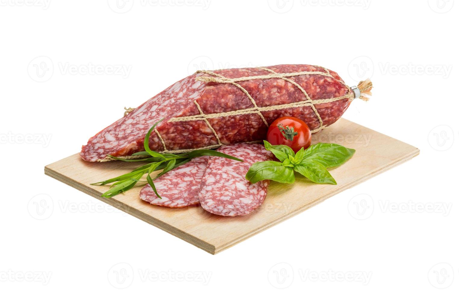 salami Aan houten bord en wit achtergrond foto