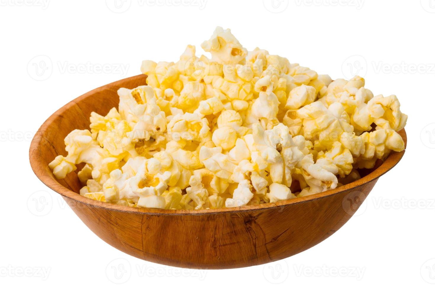 popcorn in een kom op witte achtergrond foto