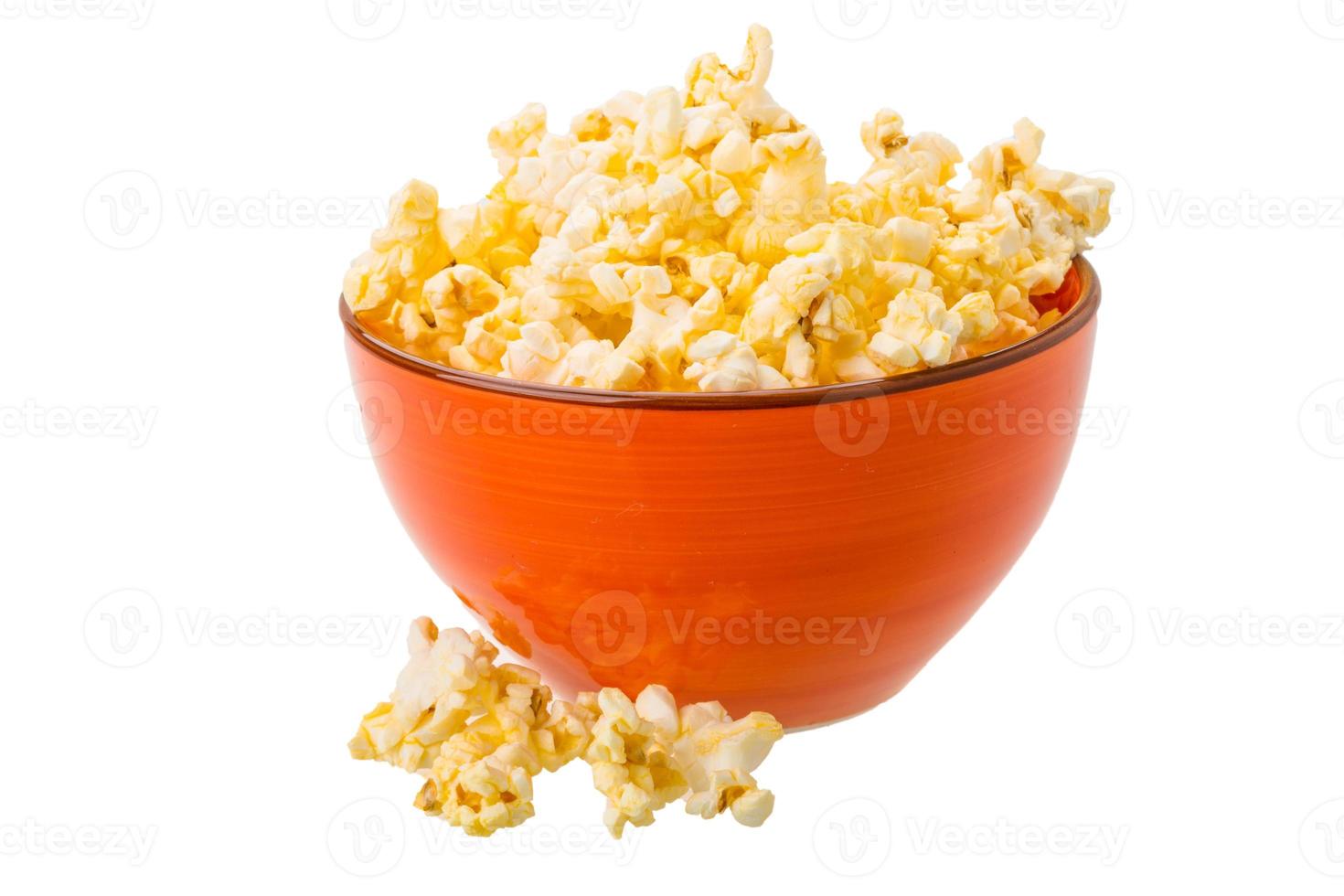 popcorn in een kom op witte achtergrond foto