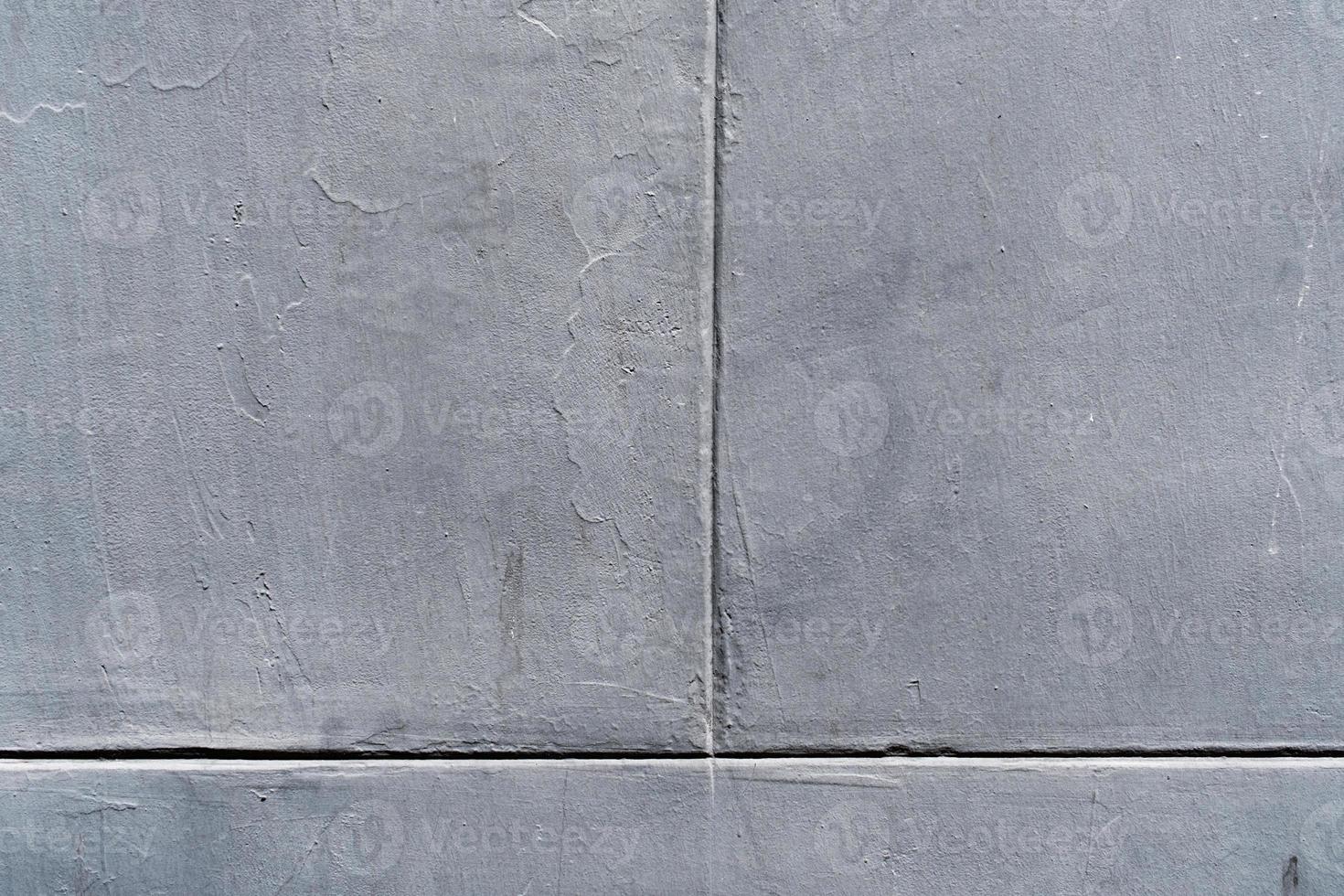beton muur geschilderd in grafiet kleur, textuur, grijs getextureerde bekleed facade, vuil grunge achtergrond, verweerd grijs stucwerk Aan de cement vloer. foto