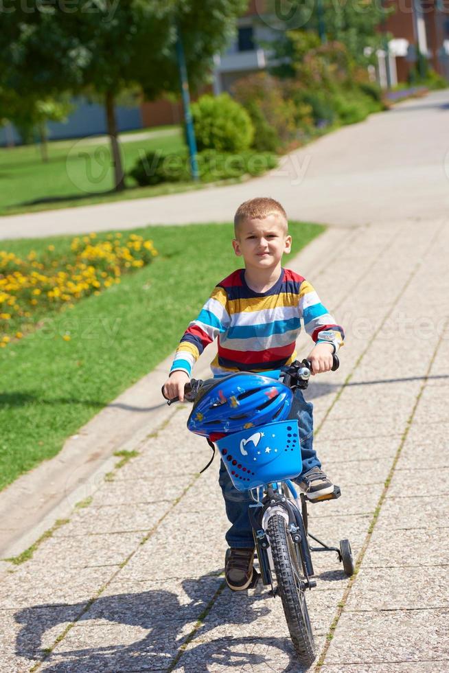 gelukkig jongen aan het leren naar rijden zijn eerste fiets foto