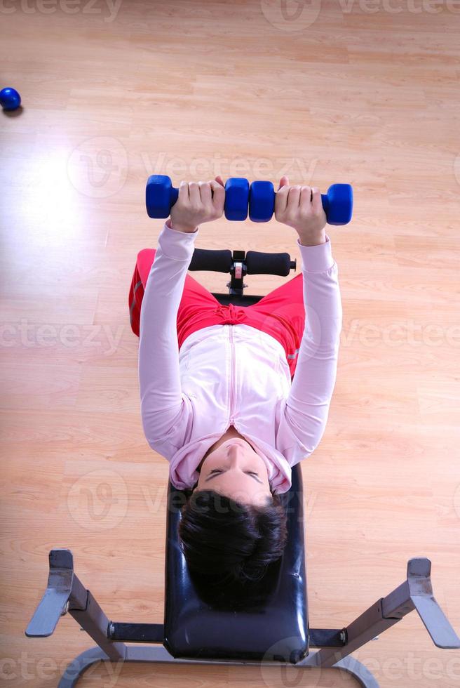 .a jong vrouw gewichtheffen Bij Sportschool foto