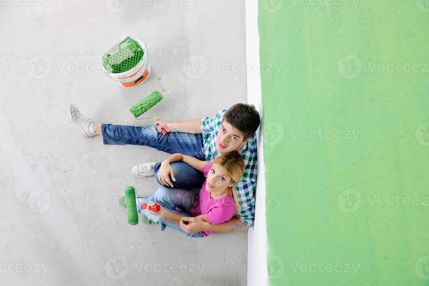 gelukkig jong cople ontspannende na schilderij in nieuw huis foto