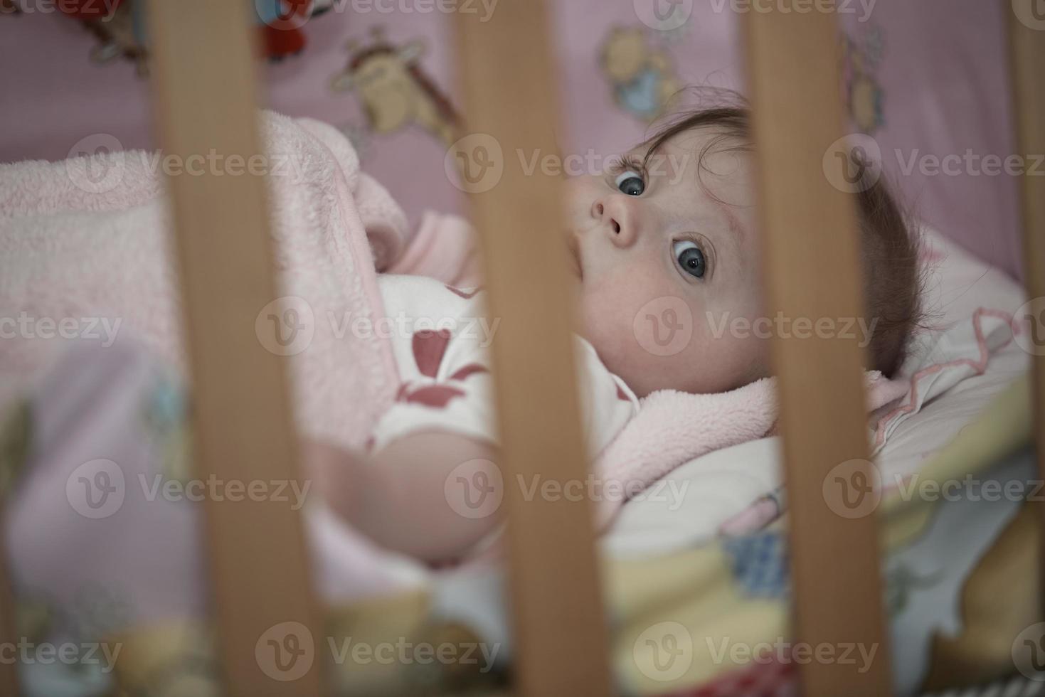 schattig weinig baby spelen met handen en glimlachen foto