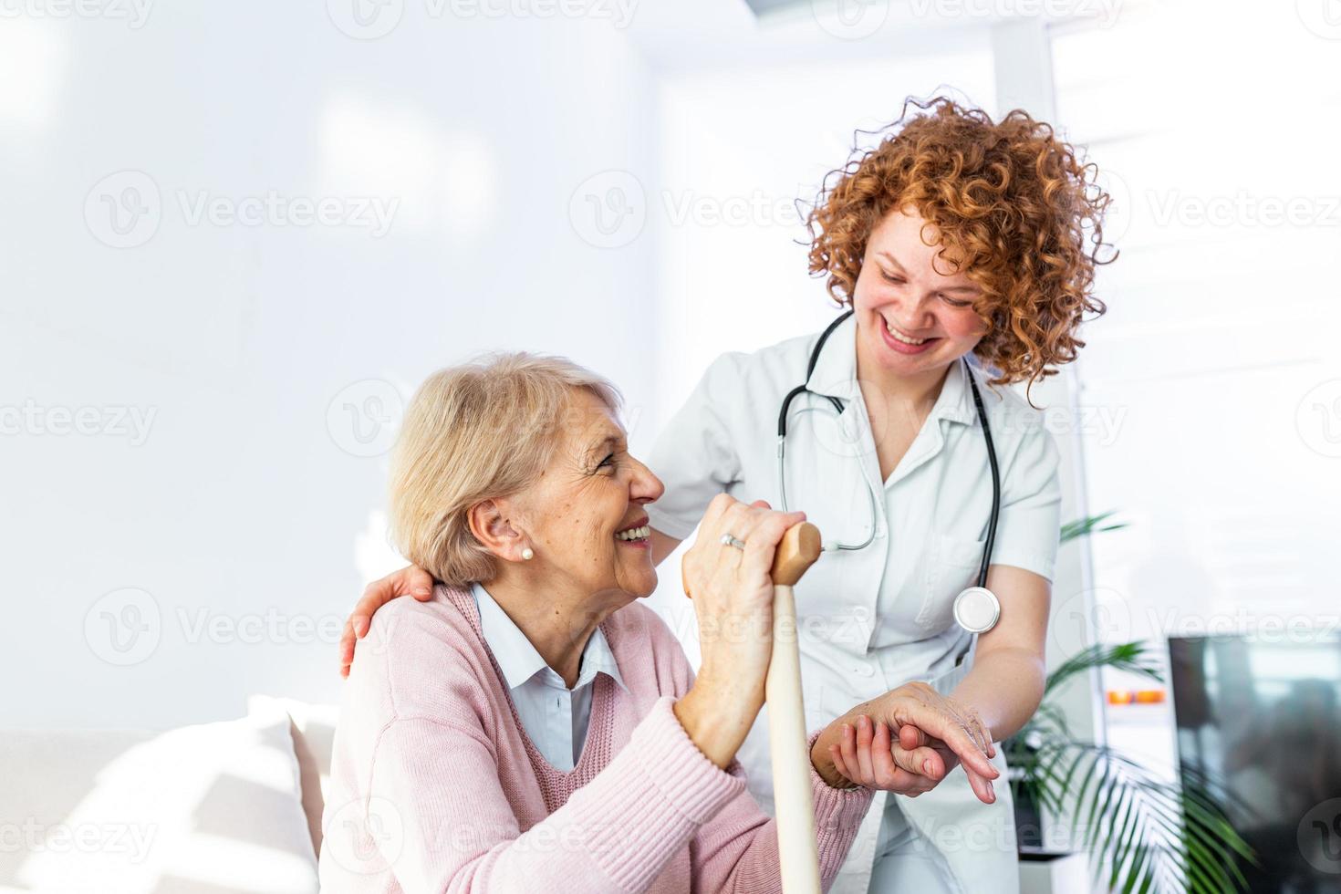 vriendelijk verhouding tussen glimlachen verzorger in uniform en gelukkig ouderen vrouw. ondersteunend jong verpleegster op zoek Bij senior vrouw. jong zorgzaam lief verzorger en gelukkig afdeling foto