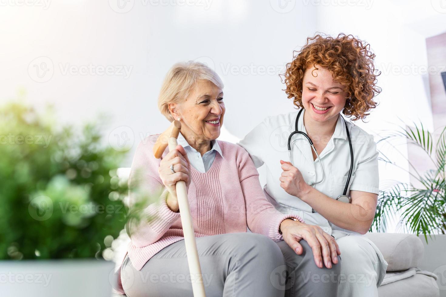vriendelijk verhouding tussen glimlachen verzorger in uniform en gelukkig ouderen vrouw. ondersteunend jong verpleegster op zoek Bij senior vrouw. jong zorgzaam lief verzorger en gelukkig afdeling foto