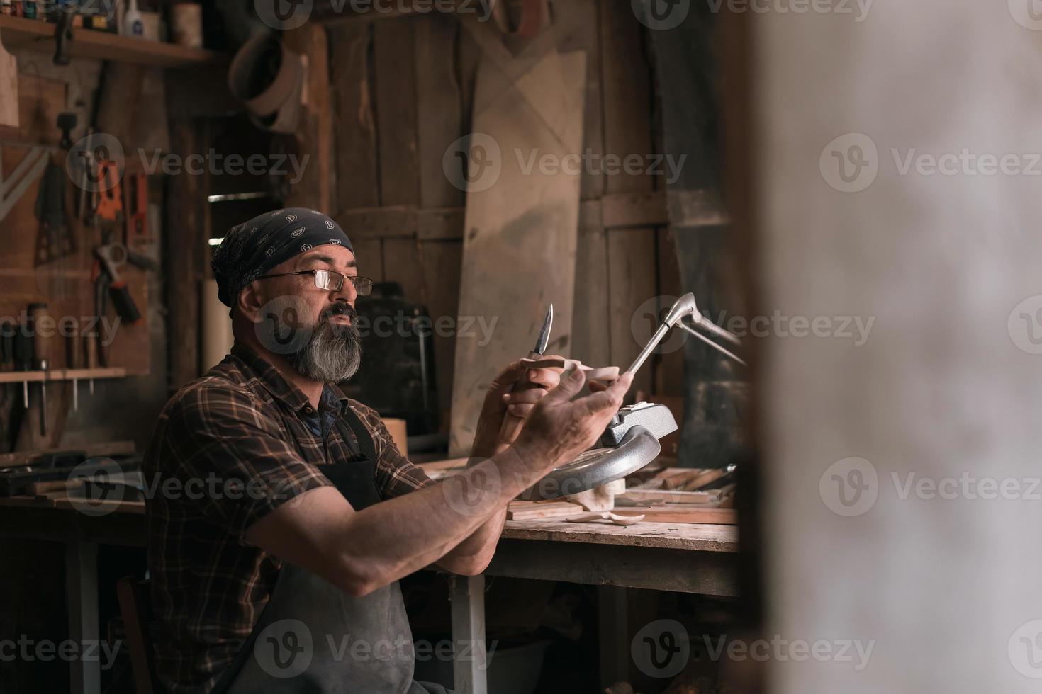 lepel meester in zijn werkplaats met houten producten en gereedschap foto