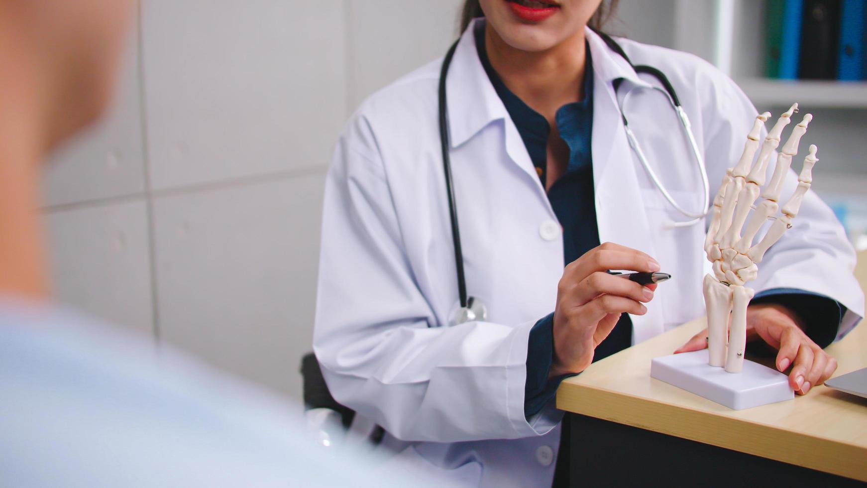 een vrouw dokter is uitleggen naar de geduldig de oorzaak van de patiënten voorwaarde. foto