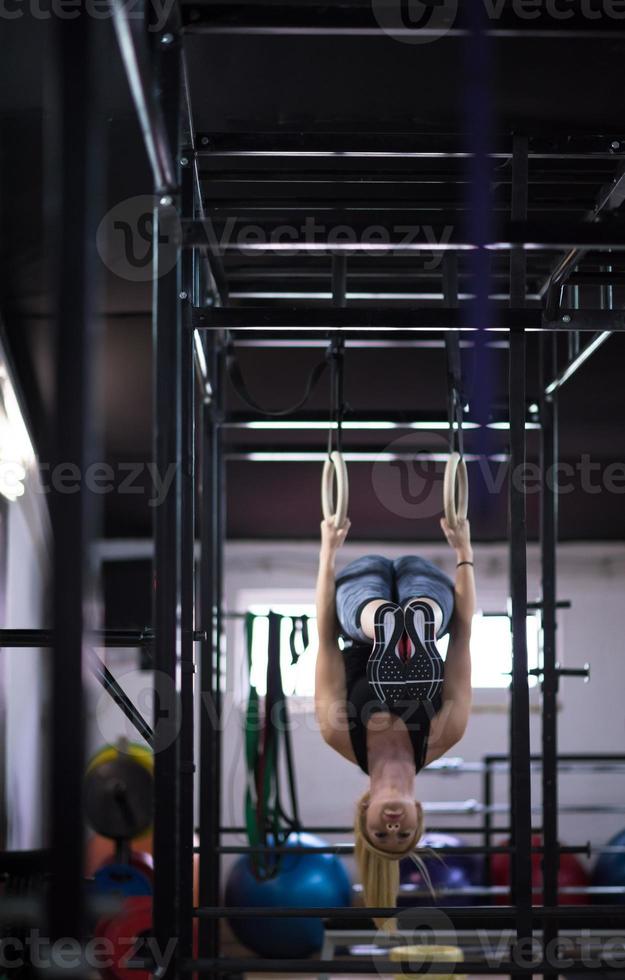 vrouw werken uit Aan gymnastiek- ringen foto