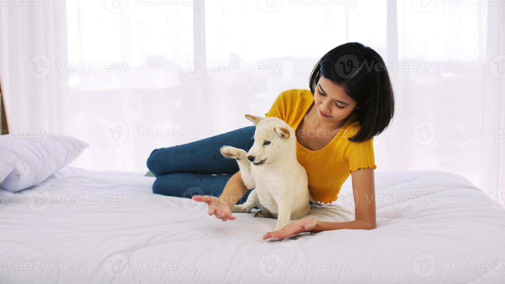 gelukkig vrouw en shiba inu hond aan het liegen samen Aan een bed Bij huis foto