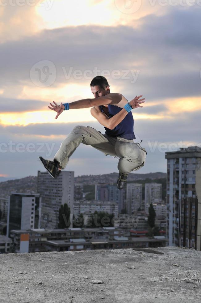 jong Mens jumping in lucht buitenshuis Bij nacht klaar voor partij foto