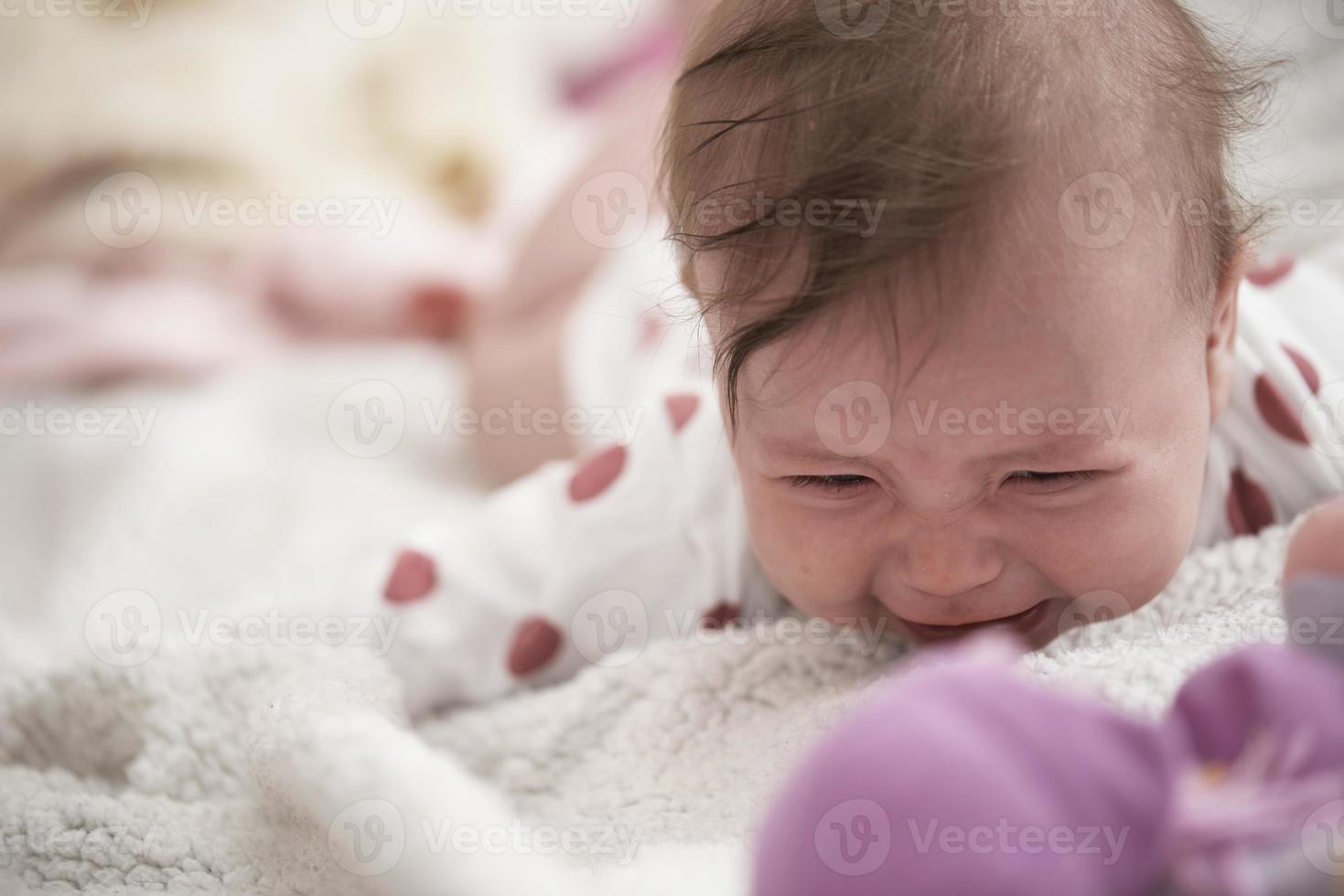 schattig weinig baby spelen met handen en glimlachen foto