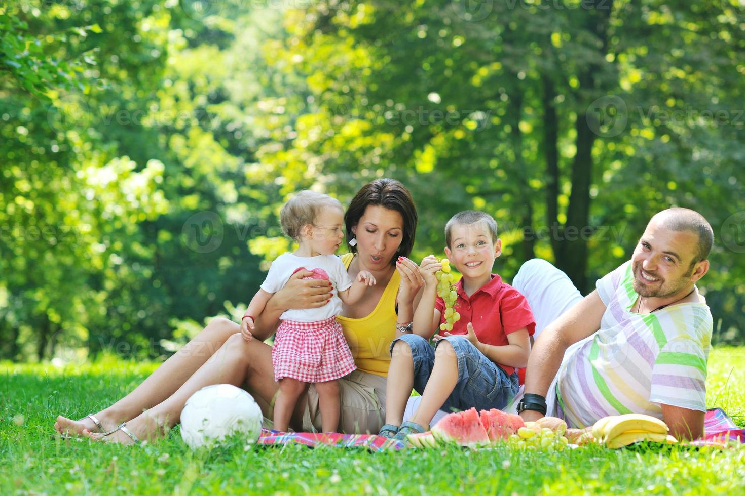 gelukkig jong koppel met hun kinderen veel plezier in het park foto