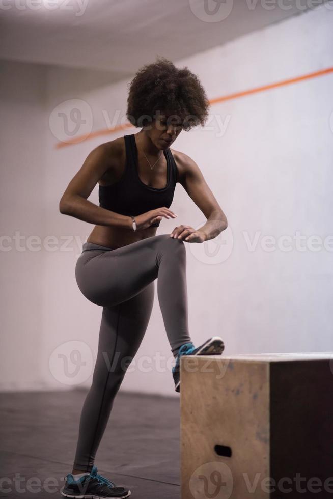 zwart vrouw zijn voorbereidingen treffen voor doos springt Bij Sportschool foto