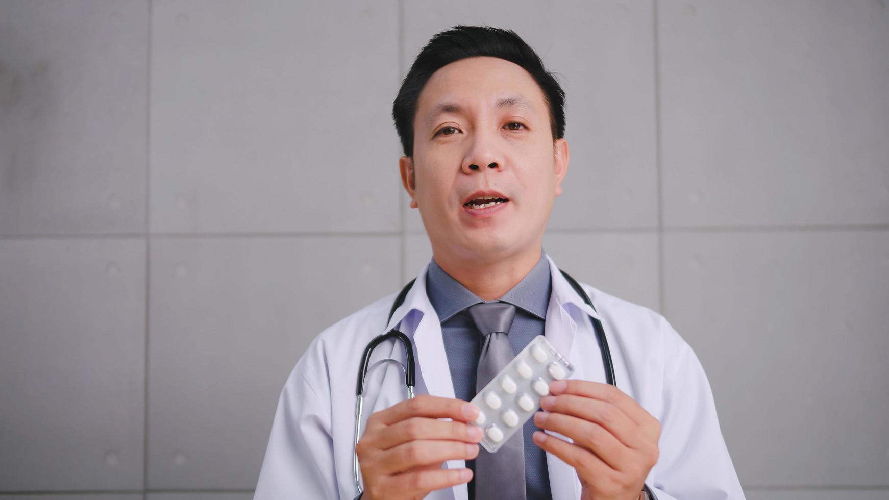 Aziatisch Mens dokter pratend met geduldig via video telefoontje conferentie. foto