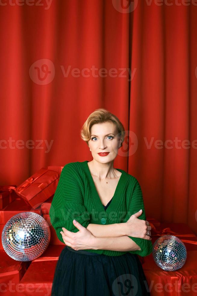 volwassen elegant elegant vrouw Aan rood achtergrond. partij, mode, viering, anti leeftijd concept. foto