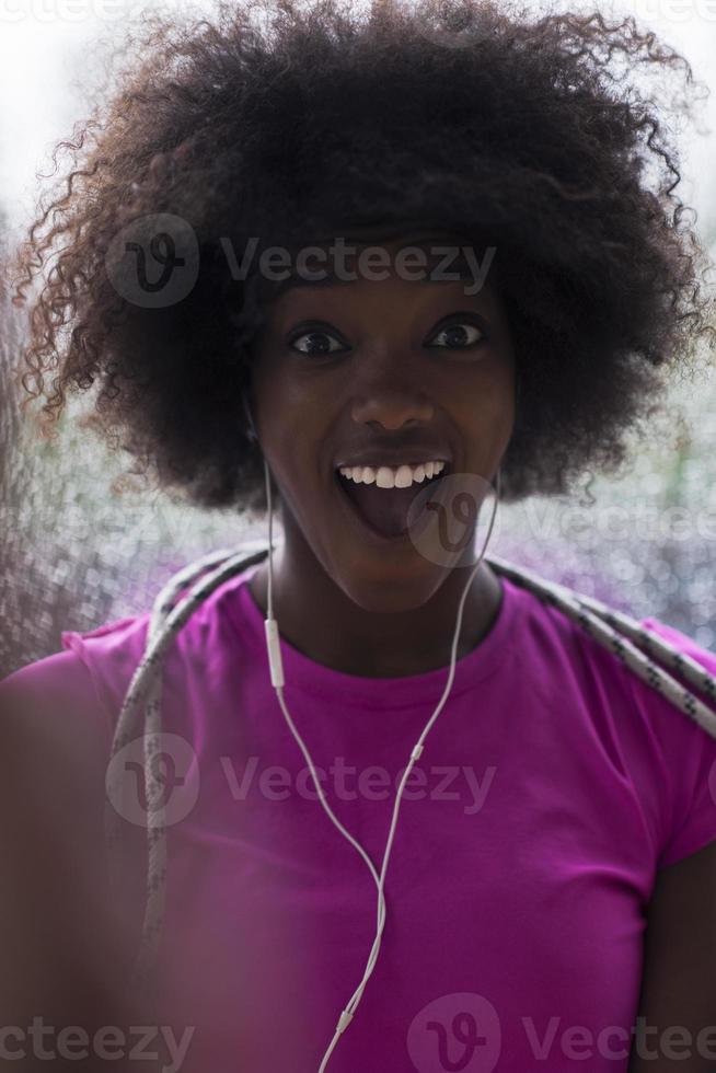 portret van jong afro Amerikaans vrouw in Sportschool terwijl luisteren muziek- foto