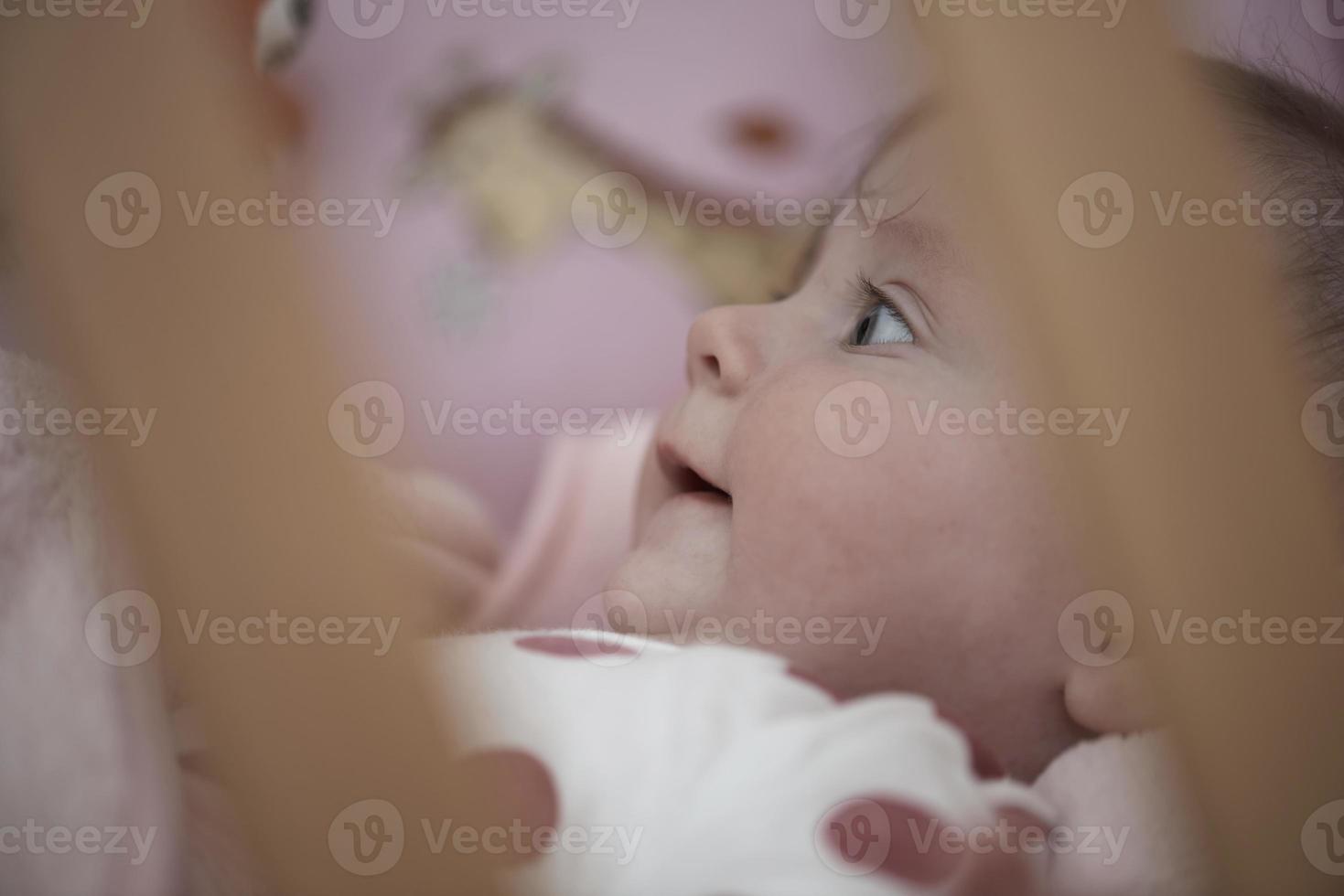 schattig weinig baby spelen met handen en glimlachen foto