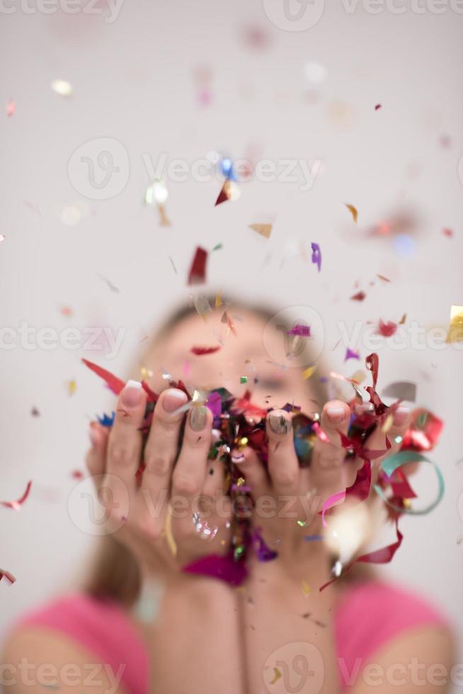 vrouw blazen confetti in de lucht foto