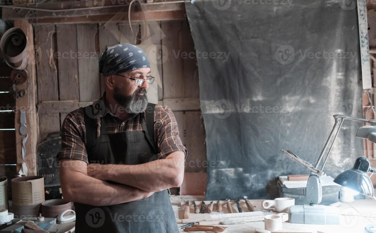 lepel meester in zijn werkplaats met houten producten en gereedschap foto