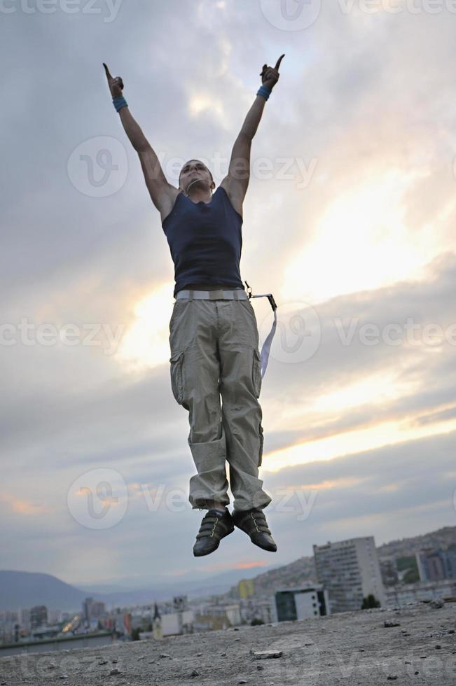 jong Mens jumping in lucht buitenshuis Bij nacht klaar voor partij foto