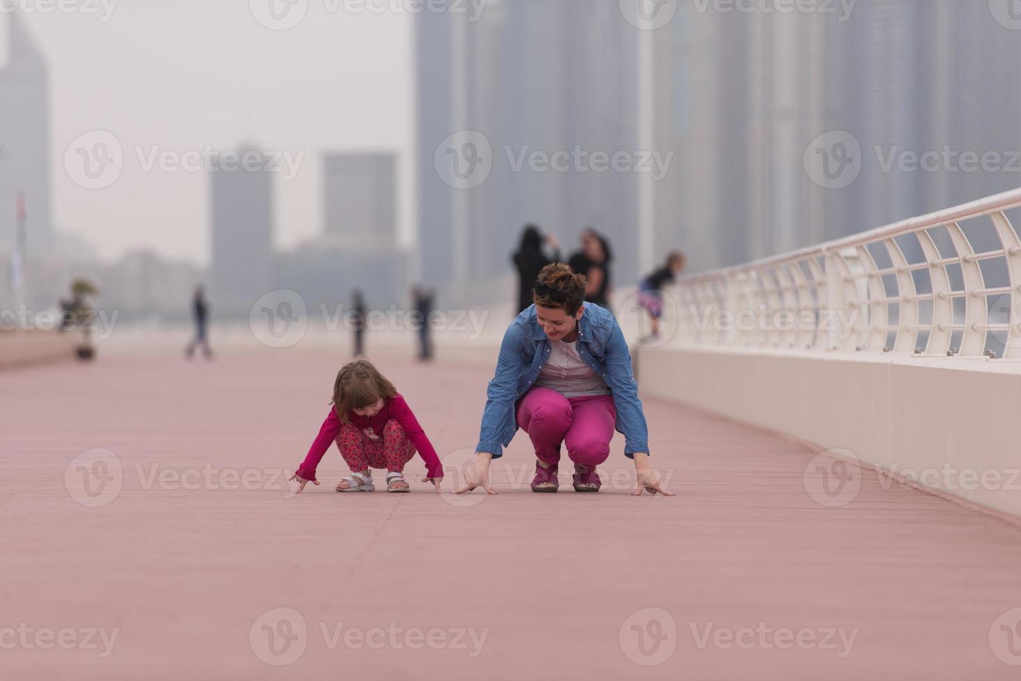 moeder en schattig weinig meisje Aan de promenade foto