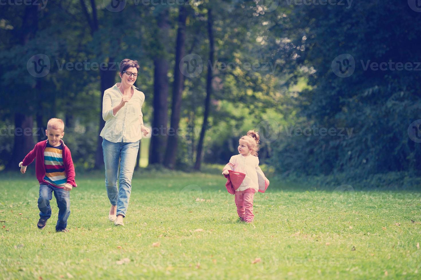 gelukkig familie spelen samen buitenshuis in park foto