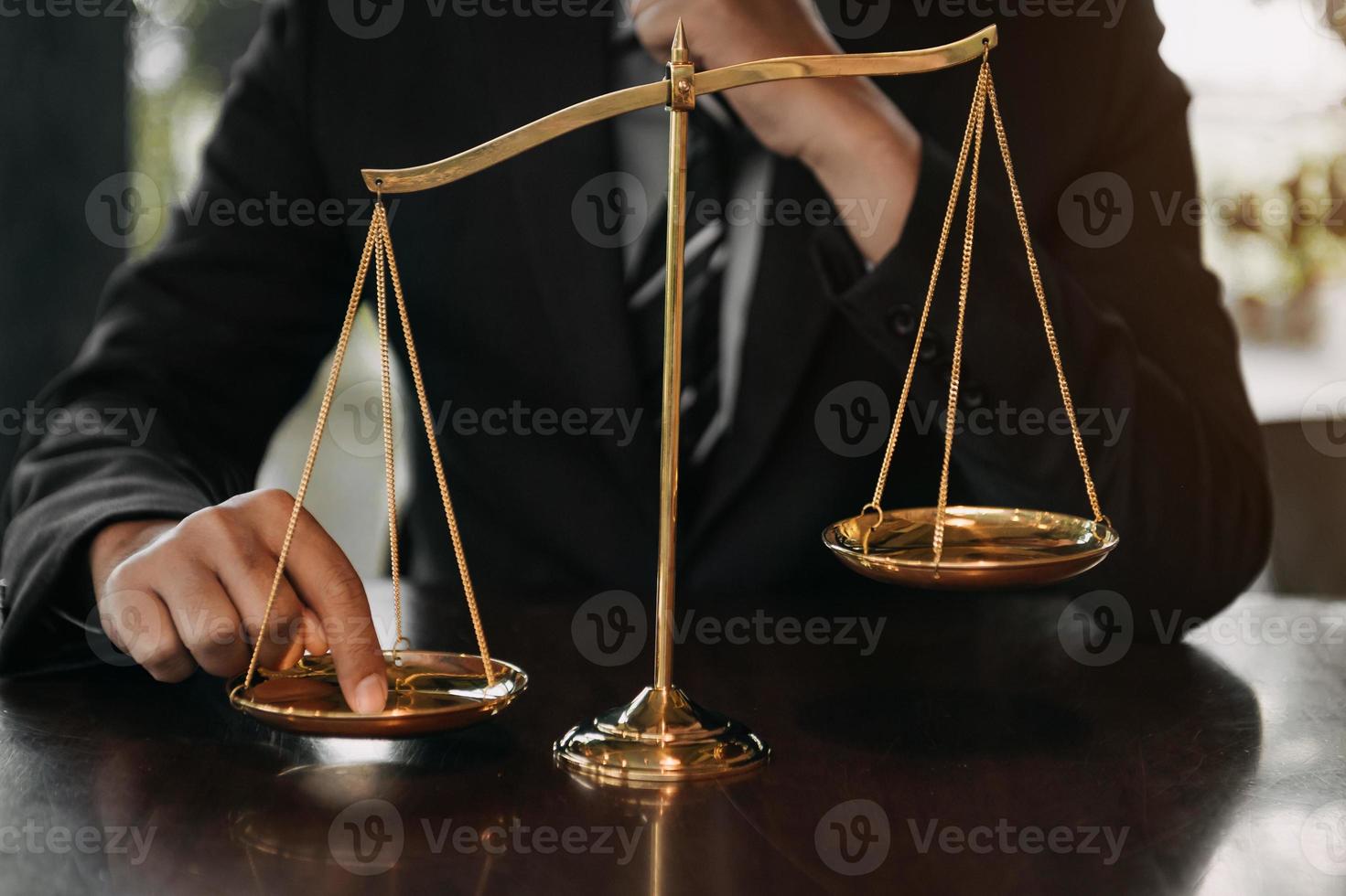 mannetje advocaat in de kantoor met messing schaal Aan houten tafel. gerechtigheid en wet concept in ochtend- licht foto