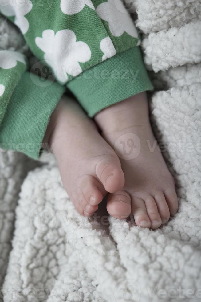 schattig weinig baby spelen met handen en glimlachen foto