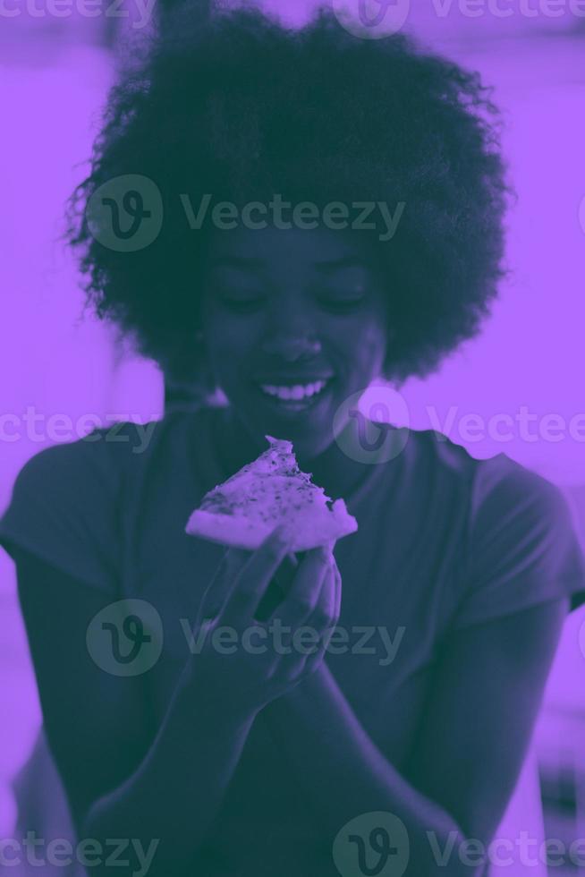 vrouw met afro kapsel aan het eten smakelijk pizza plak foto