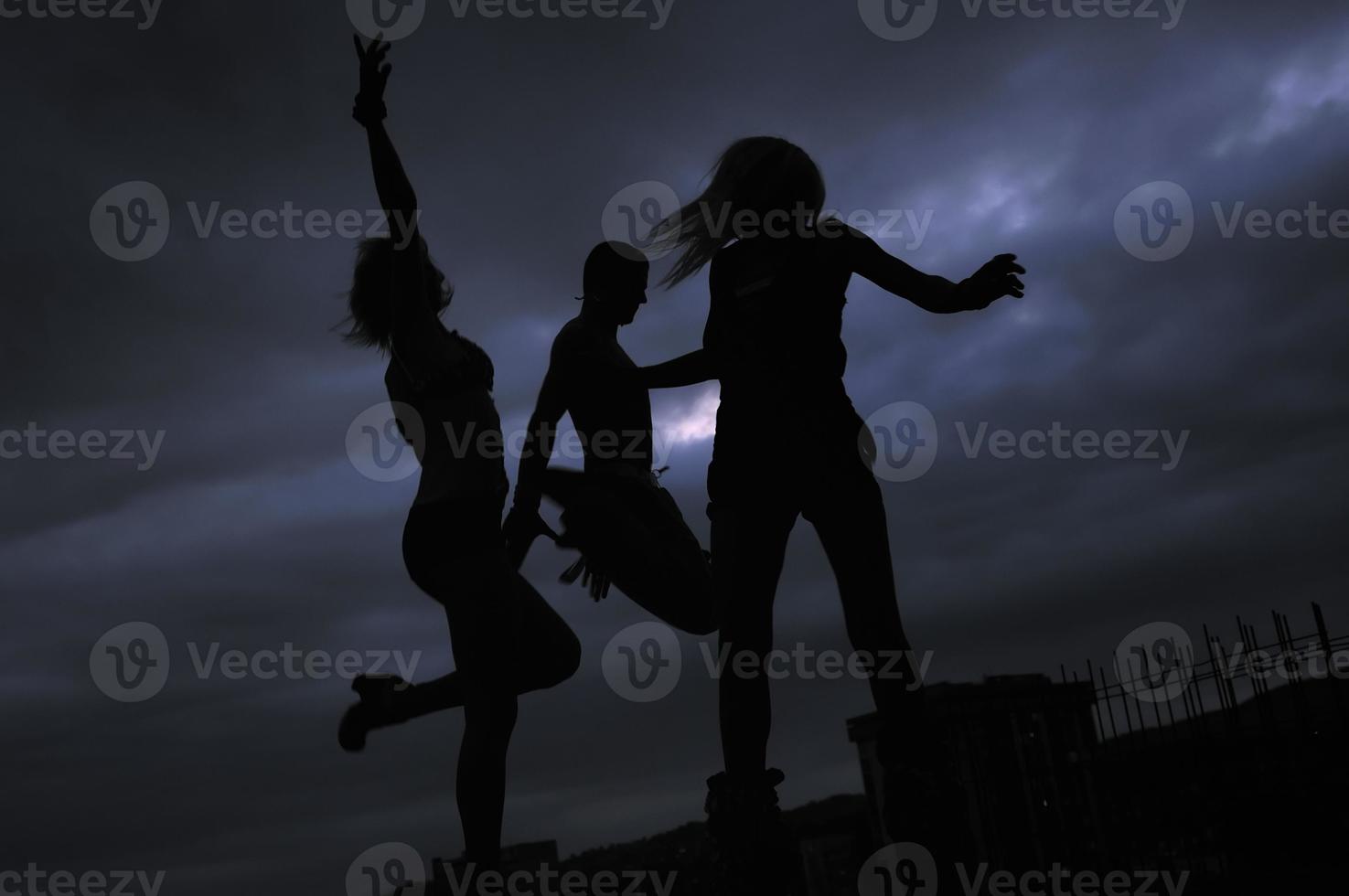 groep van mensen jumping in lucht in nacht foto